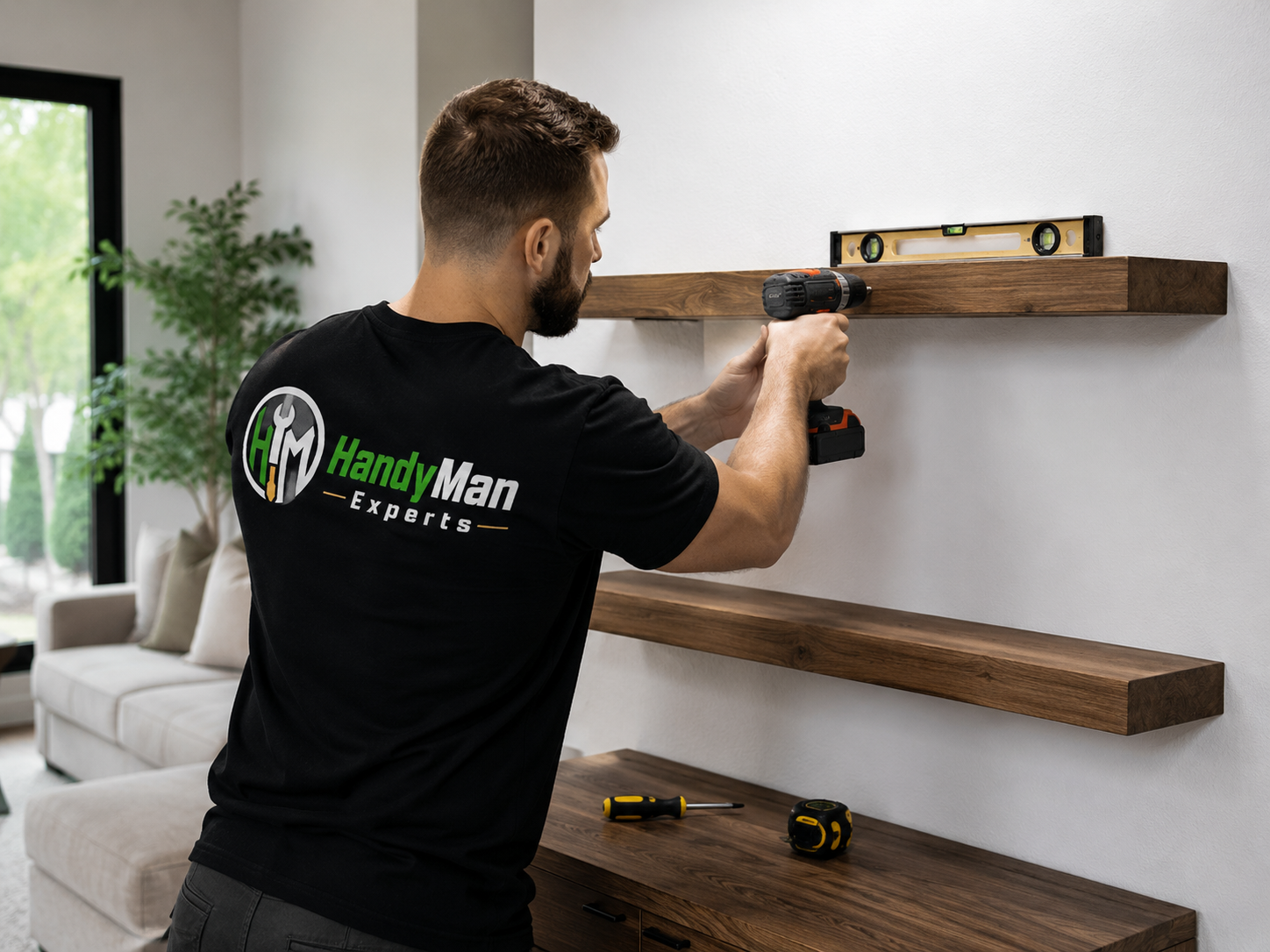 Technician installing wooden floating shelves with a drill and level